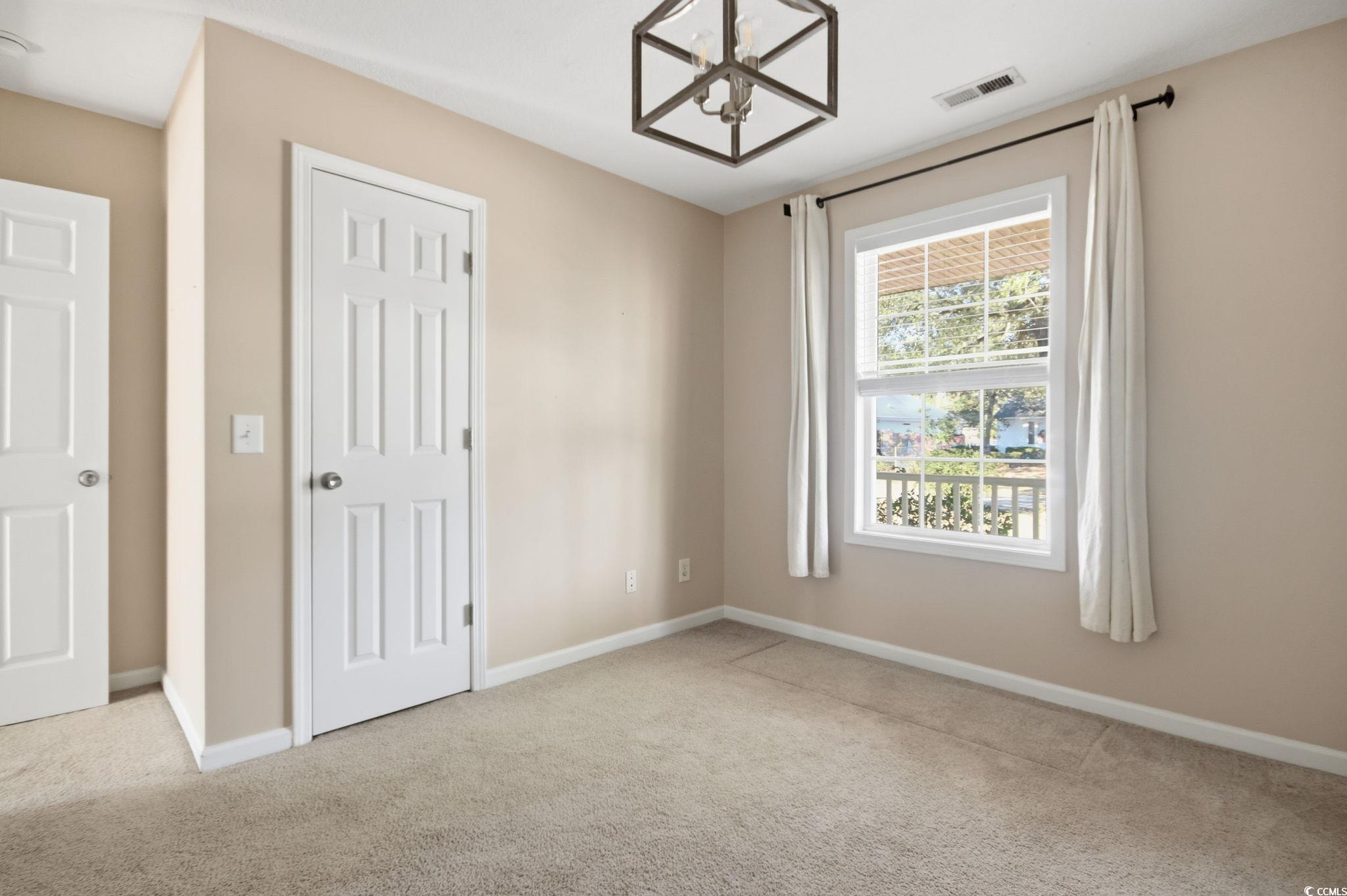 1735 Rice Street Georgetown, SC 29440 - Photo 22 of 34 Unfurnished bedroom with carpet floors and a chandelier