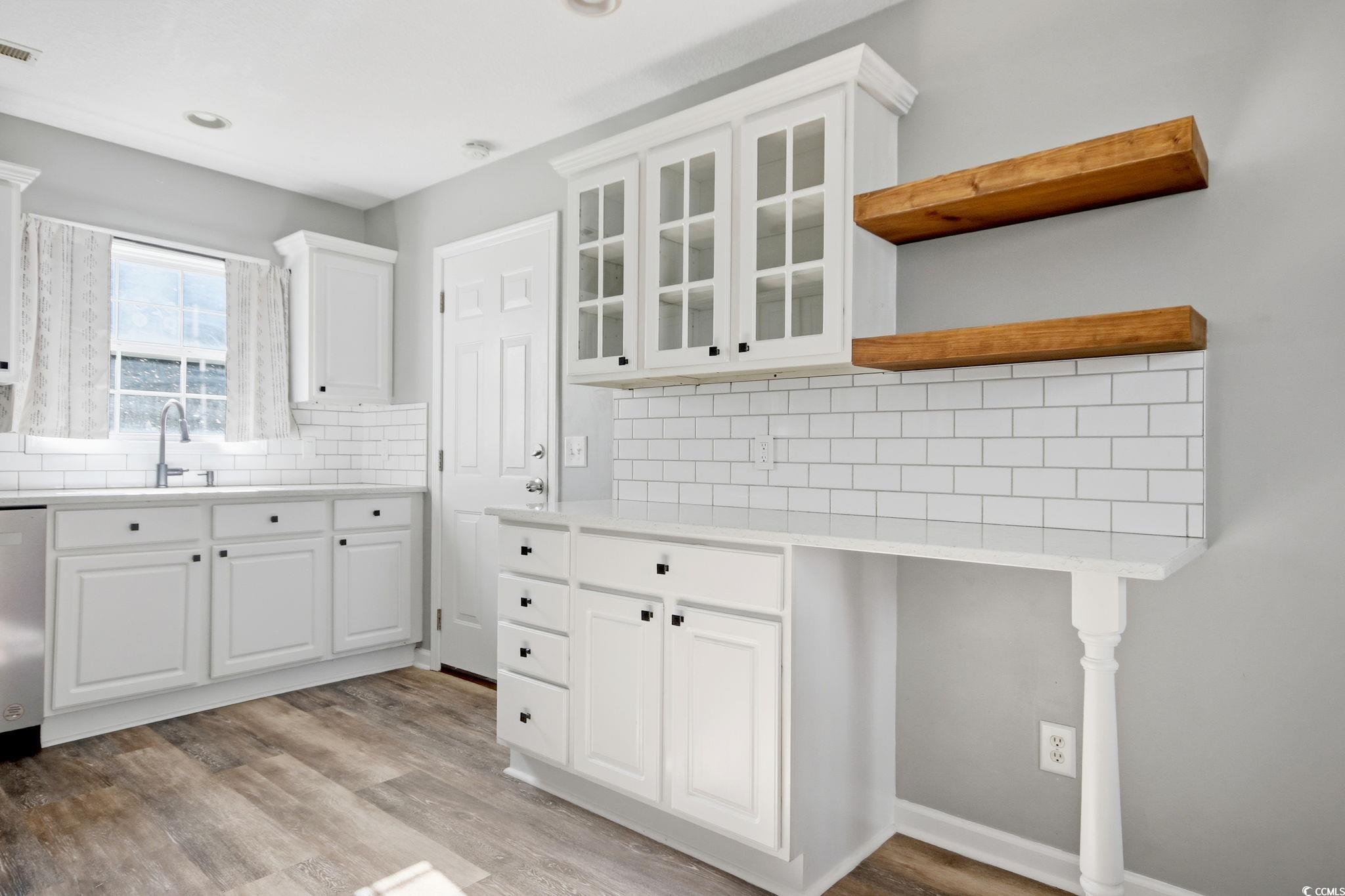 1735 Rice Street Georgetown, SC 29440 - Photo 9 of 34 Kitchen with white cabinetry, glass insert cabinets, open shelves, backsplash, and stainless steel dishwasher