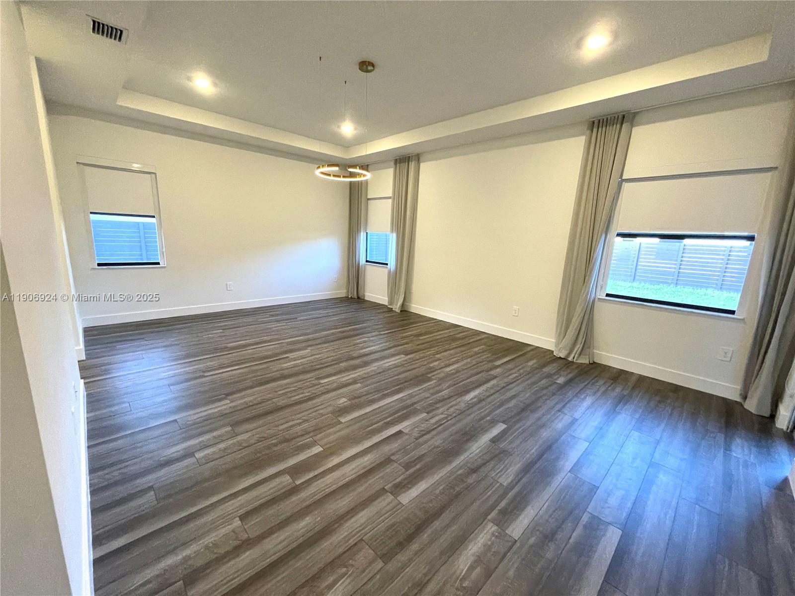 11181 Southwest 92nd Avenue, Unit 11181 Miami, FL 33176 - Photo 21 of 47 an empty room with wooden floor and windows