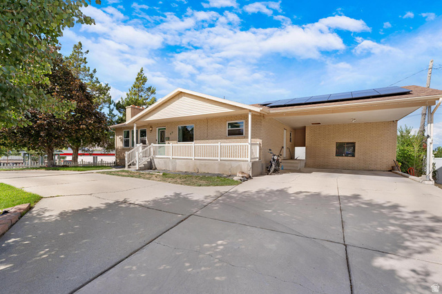 88 West 700 South Payson, UT 84651 - Photo 24 of 27 View of front of property with concrete driveway, covered porch, roof mounted solar panels, brick siding, and a carport
