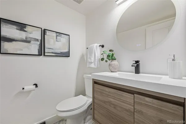a bathroom with a toilet a sink and mirror