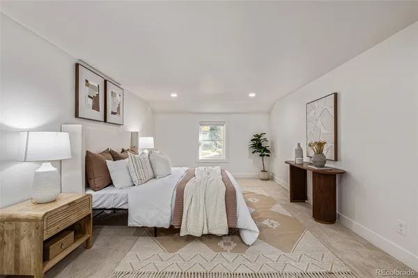 a spacious bedroom with a large bed and a chandelier