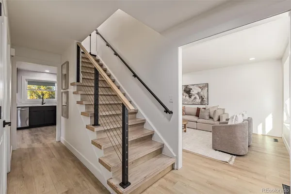 a view of a livingroom with wooden floor and stairs