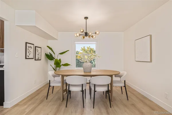 a dining room with furniture a potted plant and wooden floor