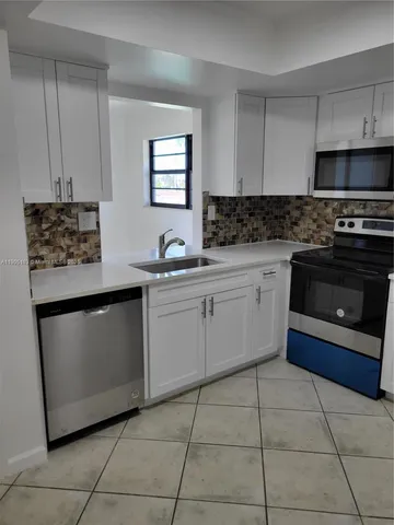 a kitchen with stainless steel appliances a sink stove and cabinets