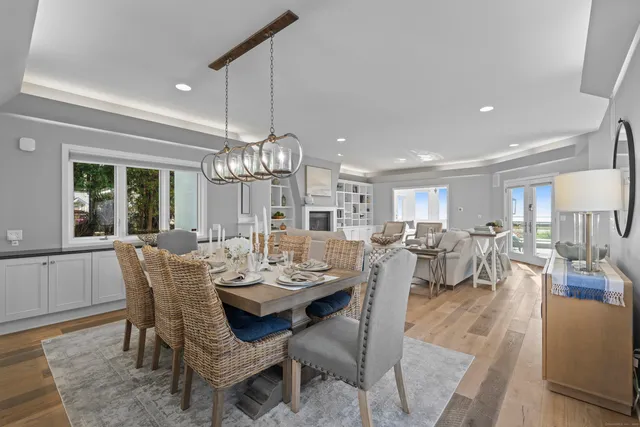 a view of a dining room and livingroom with furniture wooden floor a chandelier