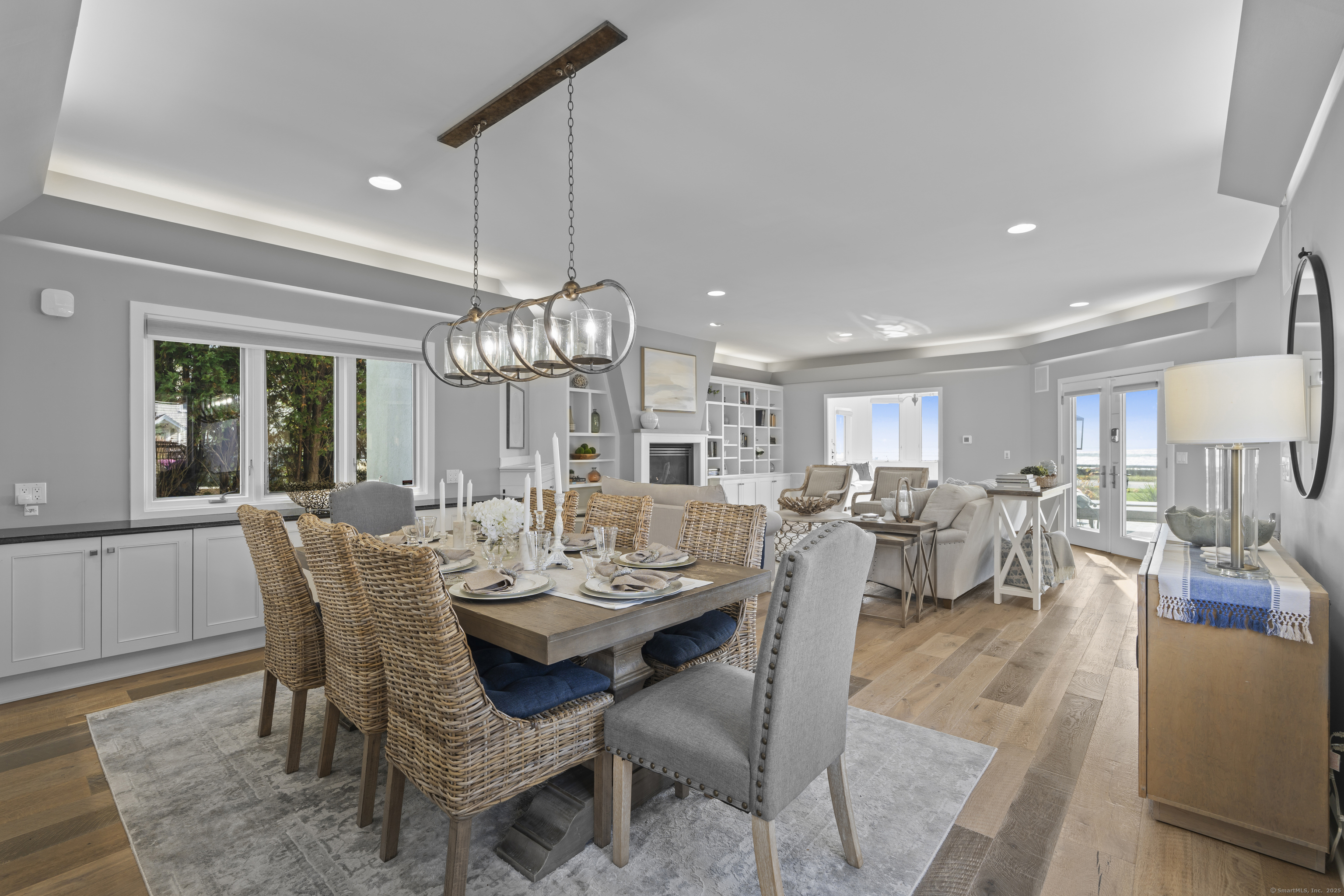 372 Maple Avenue Old Saybrook, CT 06475 - Photo 11 of 40 a view of a dining room and livingroom with furniture wooden floor a chandelier