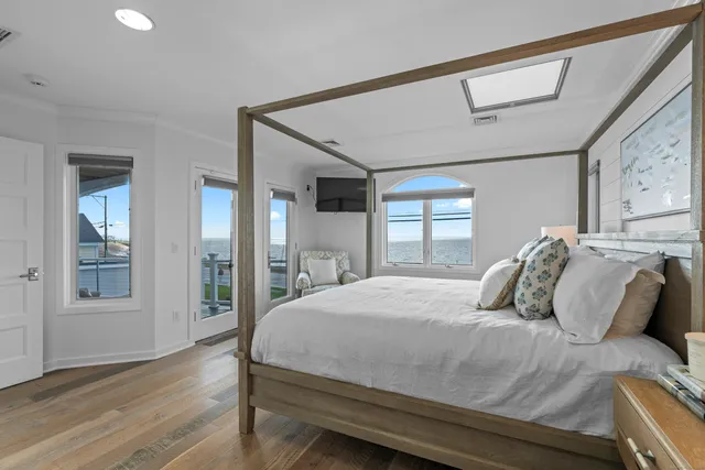 a bedroom with a large bed and wooden floor