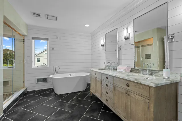 a bathroom with a double vanity sink a mirror and a bathtub