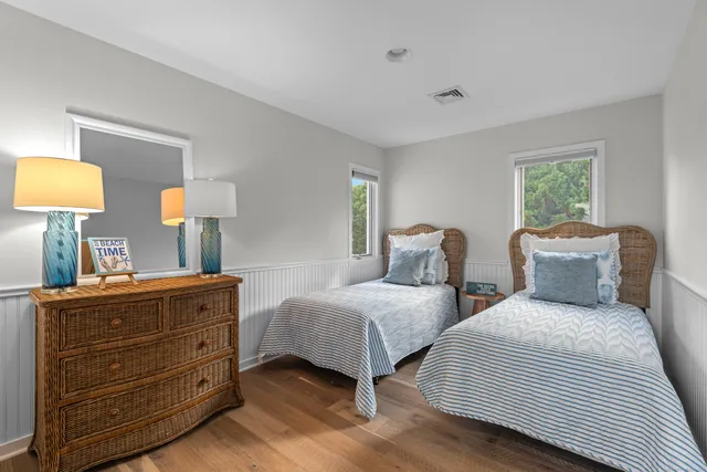 a bedroom with two beds and painting on the wall