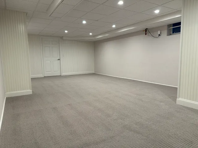 an empty room with a cabinet and mirrors