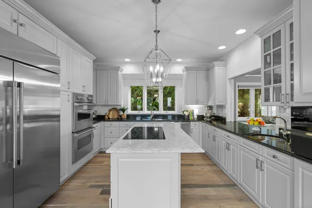 a kitchen that has a lot of cabinets and stainless steel appliances