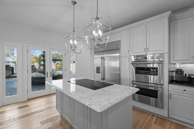 a kitchen with stainless steel appliances granite countertop a sink refrigerator and cabinets