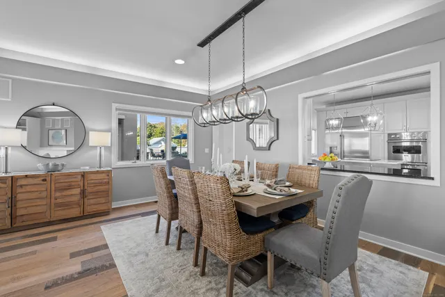 a view of a dining room with furniture a chandelier and wooden floor