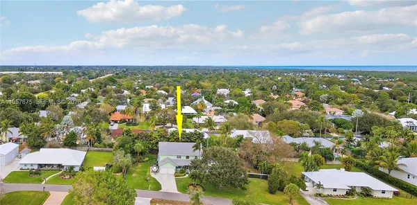 an aerial view of residential houses with outdoor space and trees