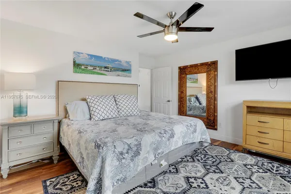 a bedroom with a bed a couch and a flat screen tv