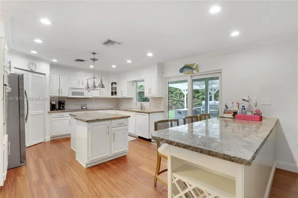 a kitchen with a center island appliances and cabinets