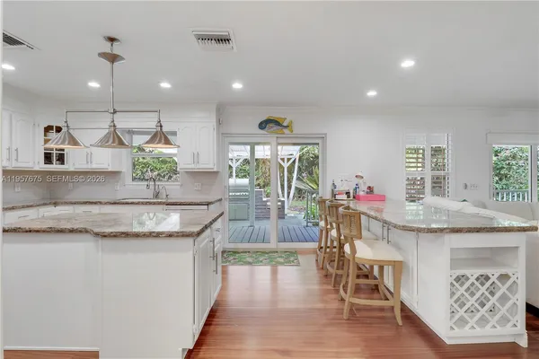 a kitchen with granite countertop a sink a counter top space and living room view