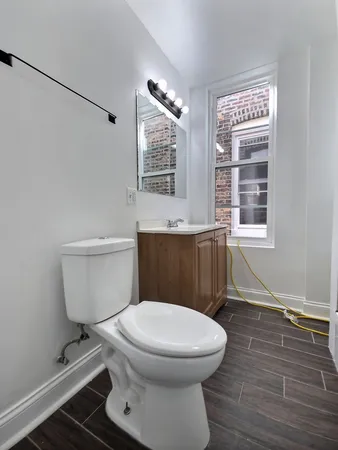 a bathroom with a toilet a sink and a window
