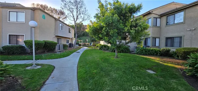 a view of a house with a yard and potted plants