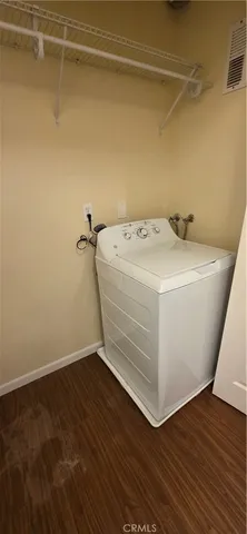 a utility room with wooden floor washer and dryer