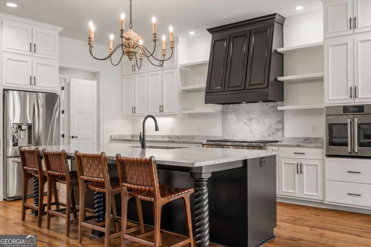 8904 Lilly Rock Way Midland, GA 31820 - Photo 7 of 49 a kitchen with cabinets wooden floor and stainless steel appliances
