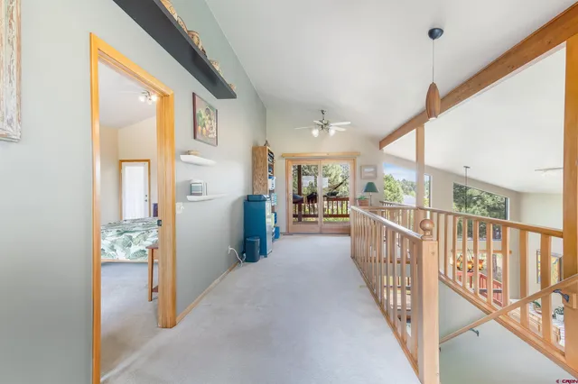 a view of a hallway with wooden floor and windows