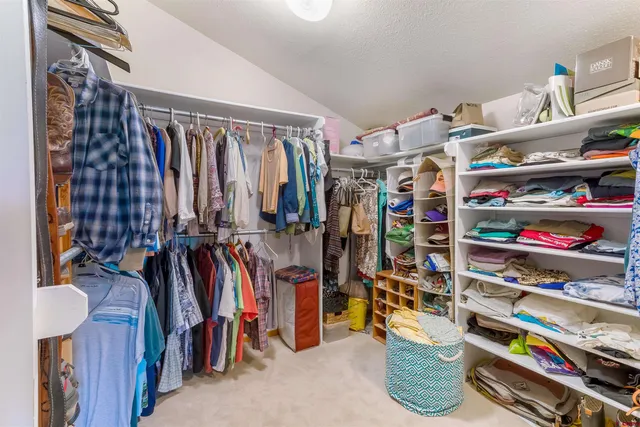a view of walk in closet with clothes and shoes