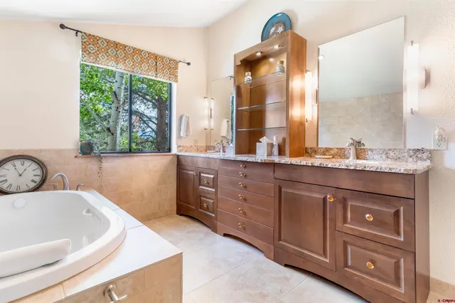 a bathroom with a tub sink and mirror