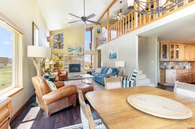 a living room with fireplace furniture and a large window
