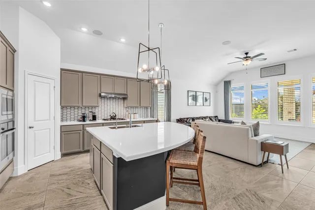 a kitchen with a dining table chairs stove and white cabinets