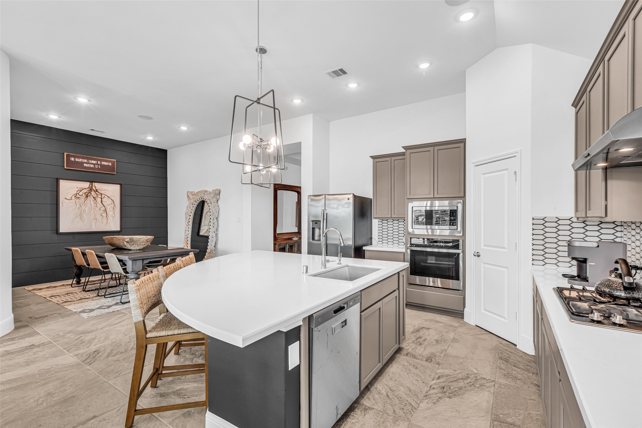 423 Bartlett Street Webster, TX 77598 - Photo 10 of 26 a kitchen with stainless steel appliances kitchen island granite countertop a stove a refrigerator a oven a sink a dining table and chairs with wooden floor
