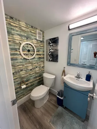 a bathroom with a toilet a sink and mirror