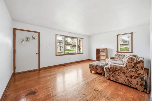 a living room with a bed and a wooden floor