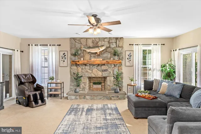 a living room with couches a coffee table and paintings on the wall with wooden floor