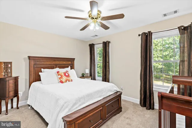 a view of a house with a yard and large trees