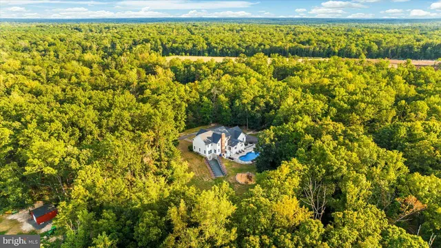 a large kitchen with stainless steel appliances kitchen island granite countertop a large kitchen island a stove a refrigerator a sink dishwasher a dining table and chairs with wooden floor