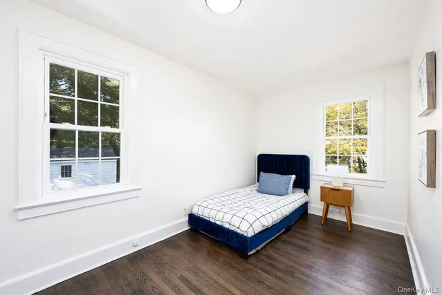 a bedroom with a bed window and wooden floor