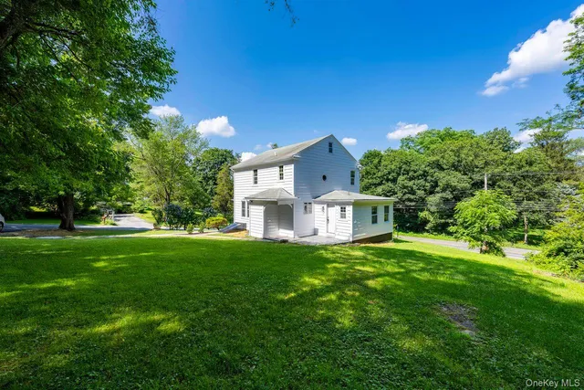 a view of a house with a big yard and large trees