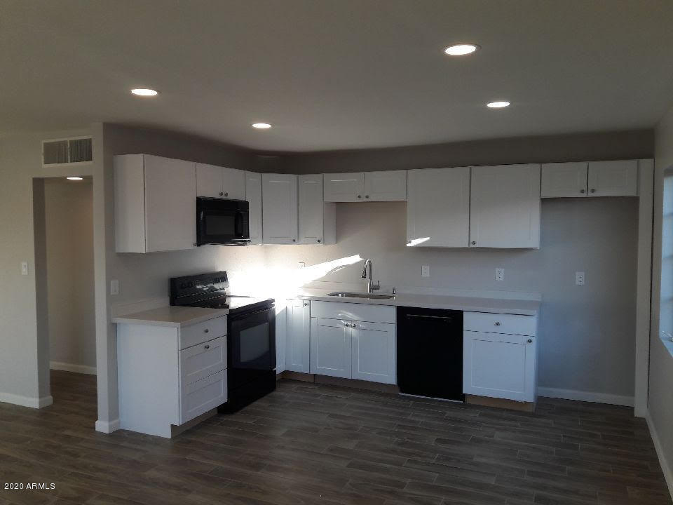 3613 West Lamar Road Phoenix, AZ 85019 - Photo 3 of 13 a kitchen with a sink a stove top oven and cabinetry
