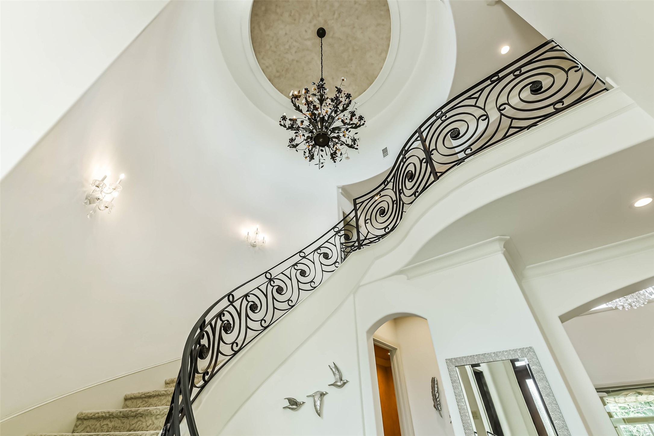 2502 Chimney Rock Road Houston, TX 77056 - Photo 22 of 50 Grand spiral staircase showcasing beautiful ironwork and the elegant chandelier complemented by soaring ceiling