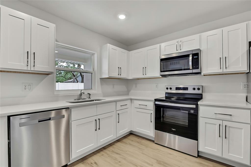 3646 Portillo Road Spring Hill, FL 34608 - Photo 5 of 16 a kitchen with white cabinets stainless steel appliances and sink