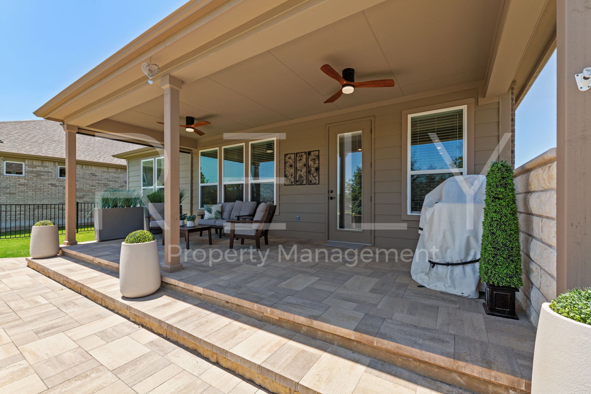 101 Spanish Star Street Georgetown, TX 78633 - Photo 36 of 39 An inviting covered patio featuring paver flooring and ceiling fans for comfortable outdoor living.