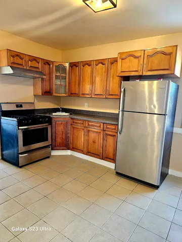 a kitchen with stainless steel appliances granite countertop a refrigerator a stove and a sink with dishwasher