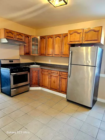 a kitchen with stainless steel appliances granite countertop a refrigerator a stove and a sink with dishwasher