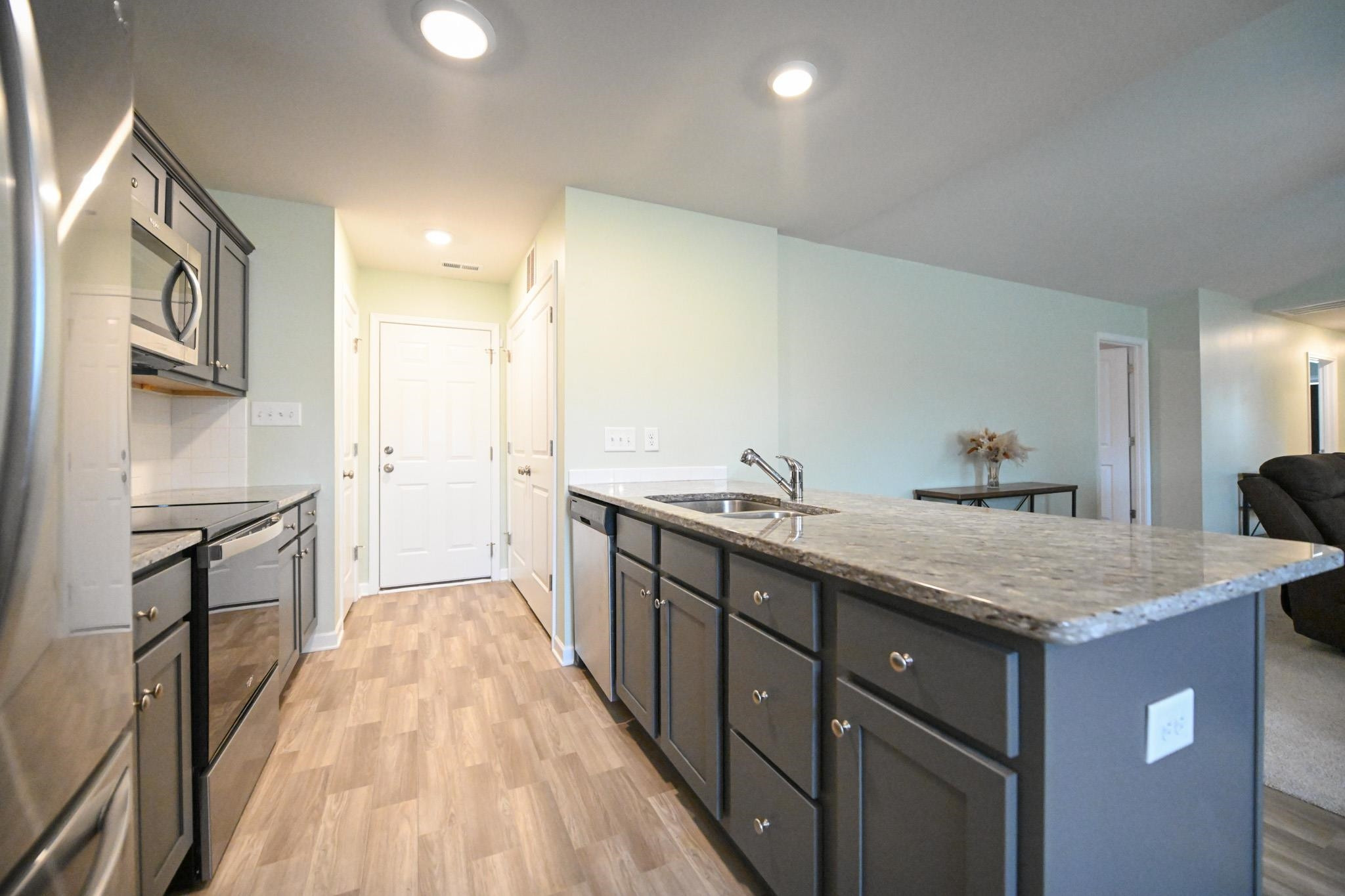 132 Winter Red Way Benson, NC 27504 - Photo 13 of 33 a kitchen with granite countertop a sink stove and refrigerator