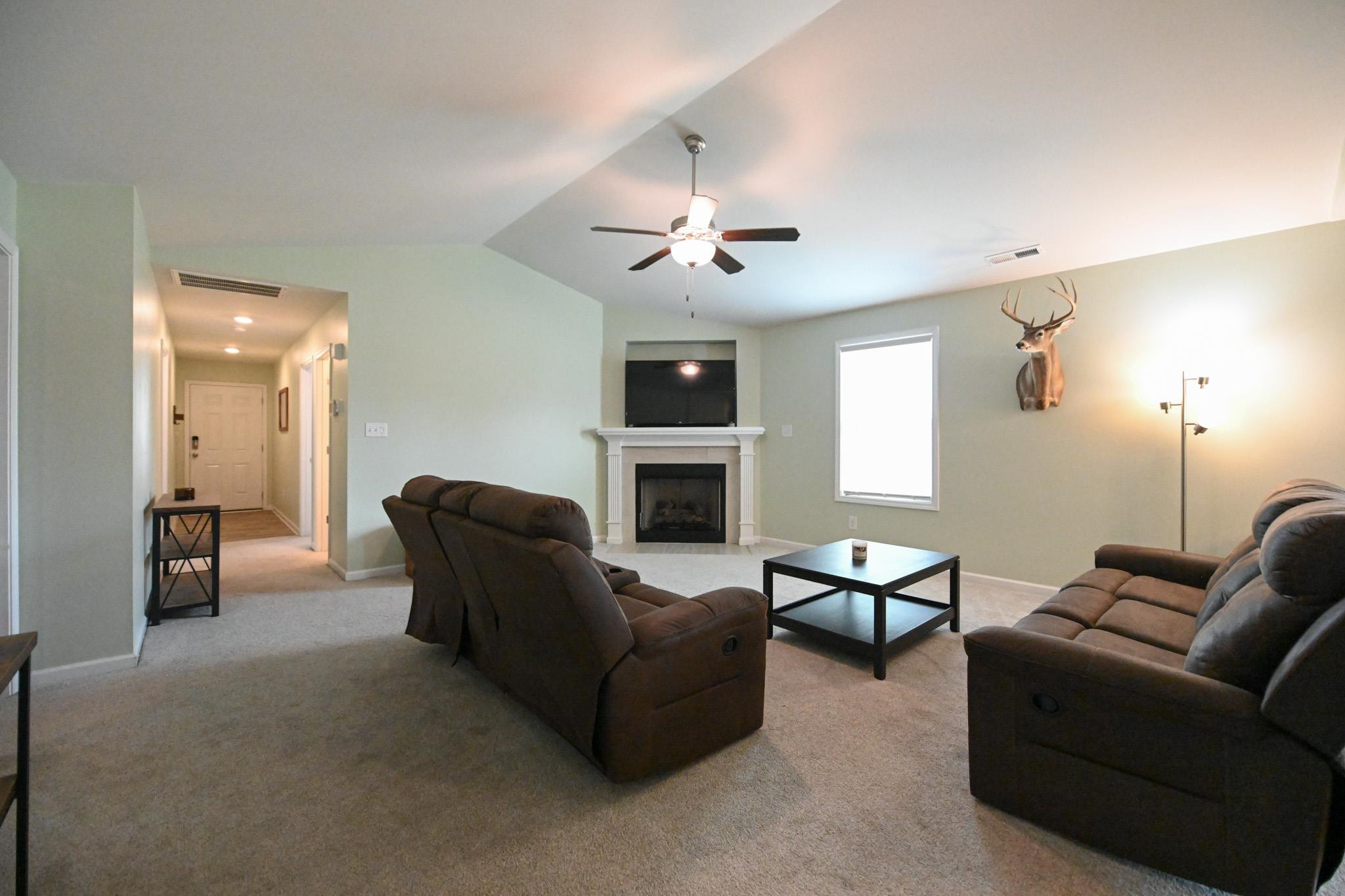132 Winter Red Way Benson, NC 27504 - Photo 3 of 33 a living room with furniture a fireplace and a flat screen tv