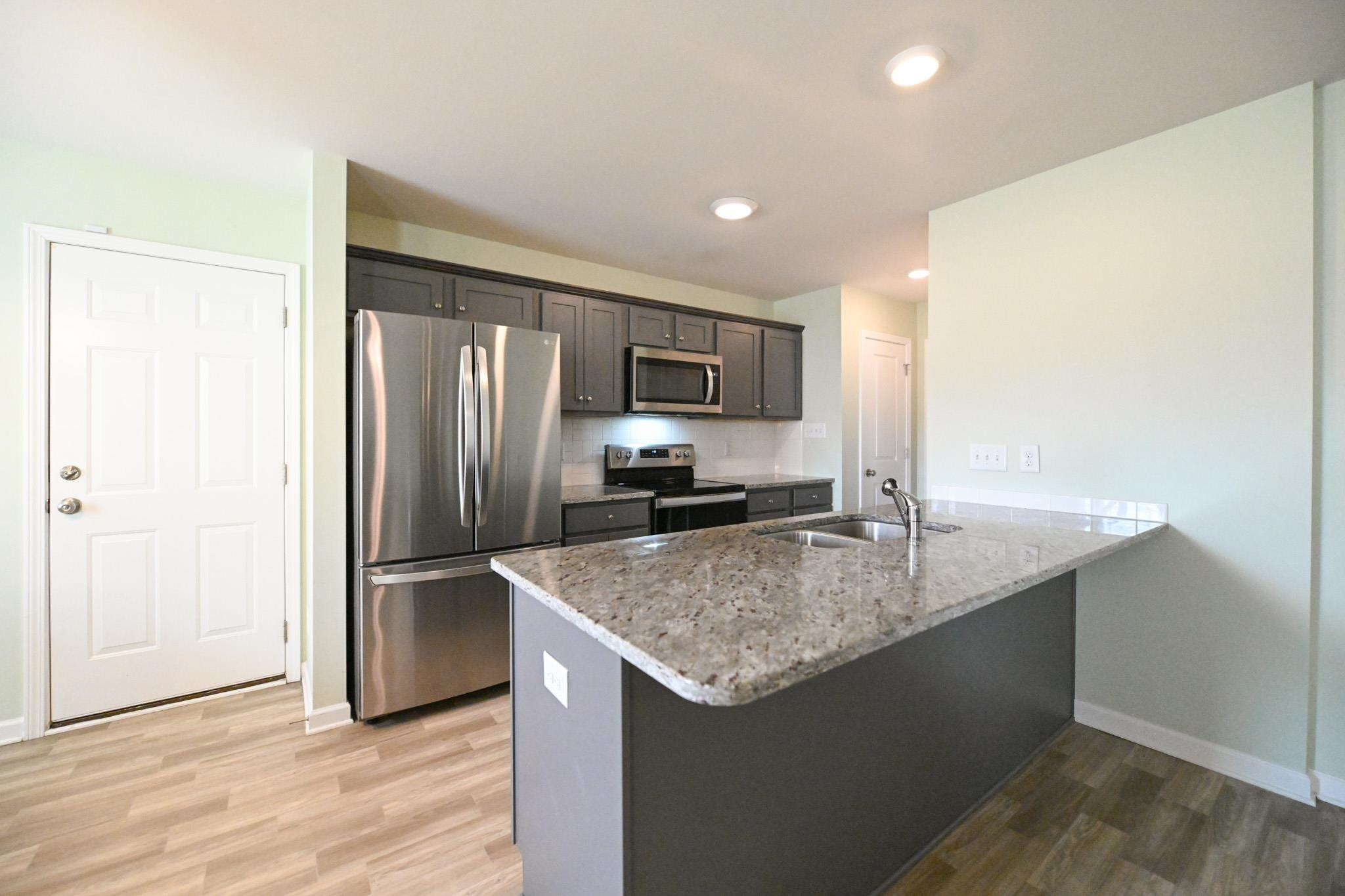 132 Winter Red Way Benson, NC 27504 - Photo 10 of 33 a kitchen with granite countertop a refrigerator and a sink