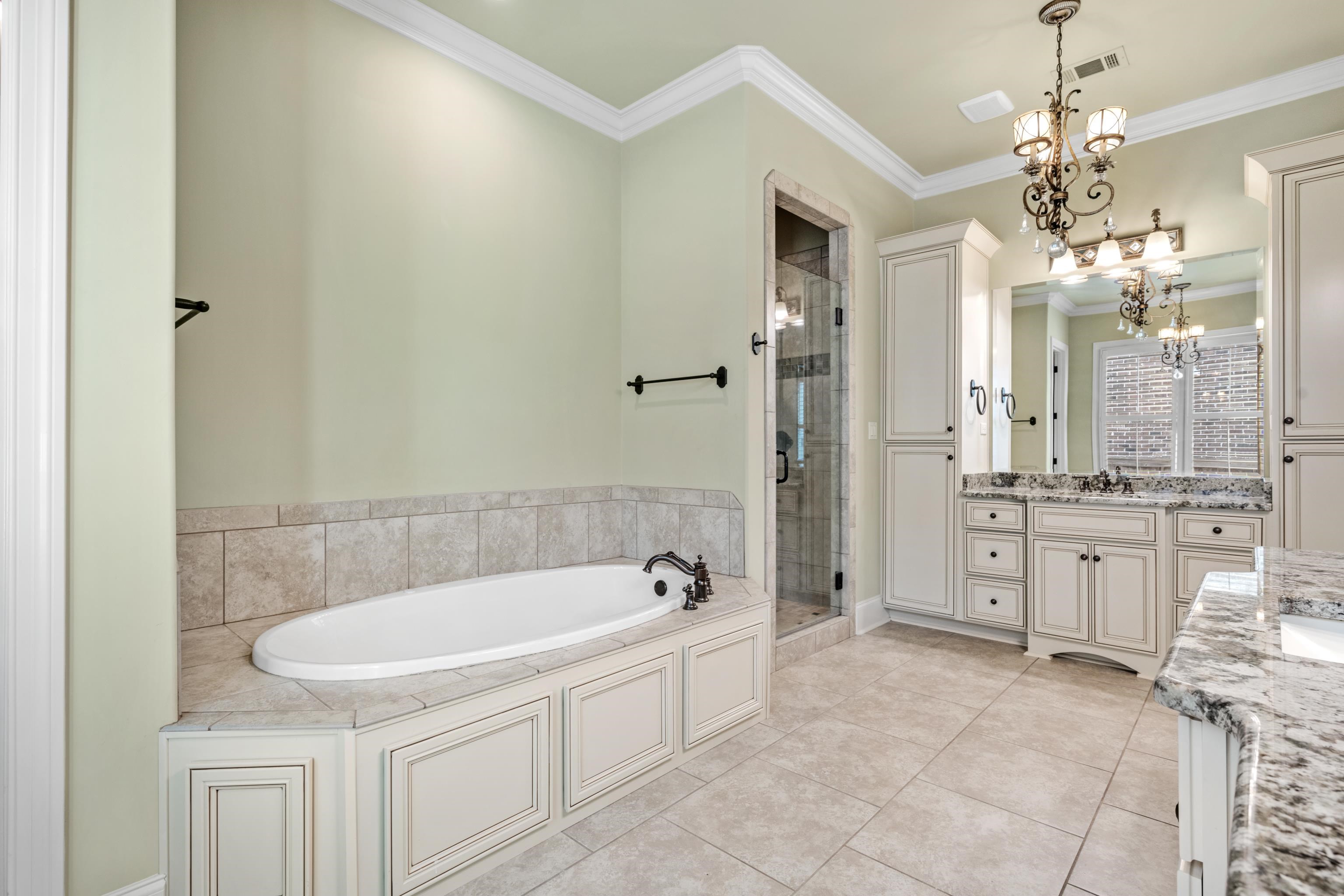 2840 Rue Jordan Cove Germantown, TN 38138 - Photo 25 of 40 a bathroom with a granite countertop sink a toilet a mirror and bathtub