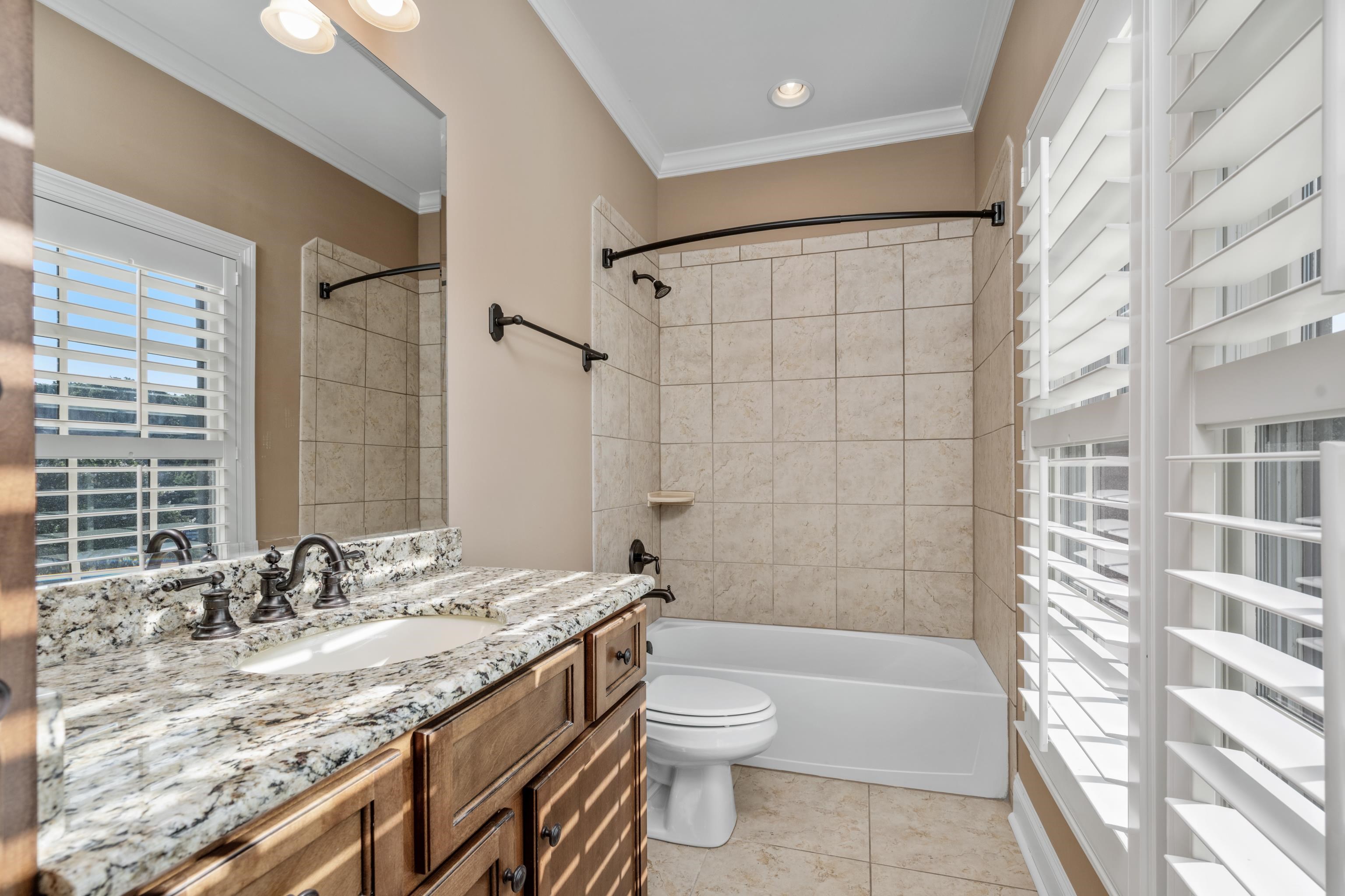 2840 Rue Jordan Cove Germantown, TN 38138 - Photo 35 of 40 a bathroom with a granite countertop sink toilet and shower